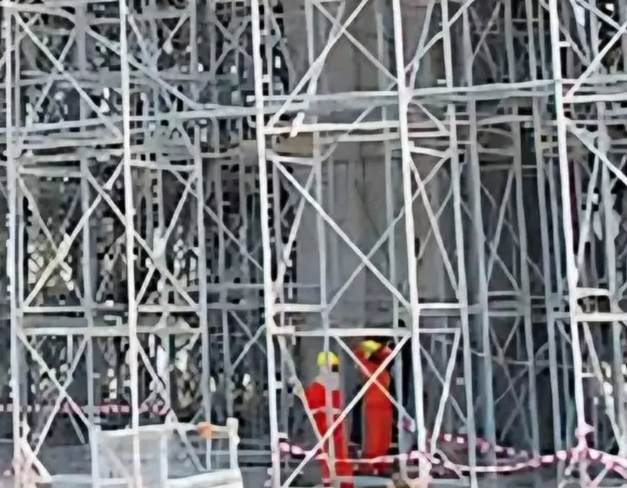Workers in safety vests on a scaffold site